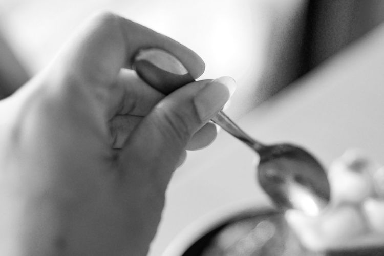 Close-up of woman hand holding spoon at home