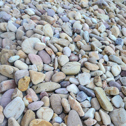 Close up of rounded and polished beach rocks on the sea shore