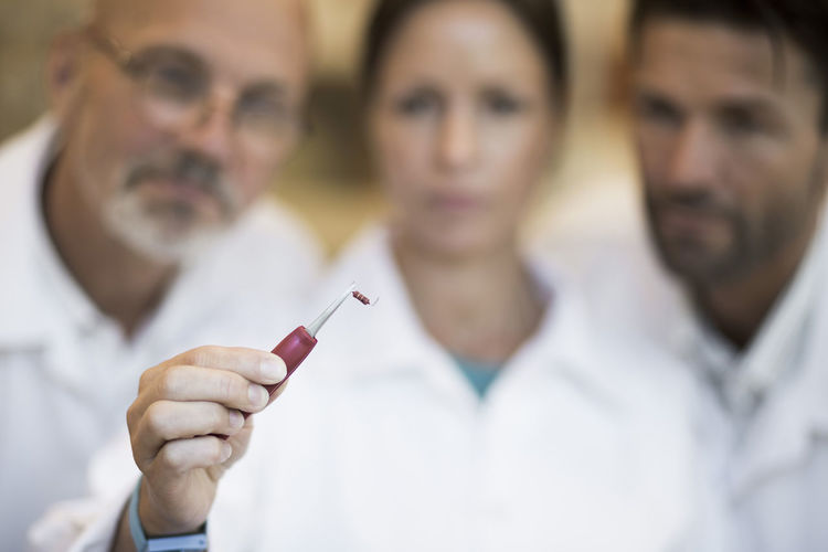 Engineers looking at resistor in manufacturing industry