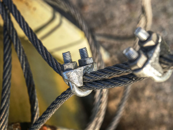 Knot of steel rope. stainless steel turnbuckle and sling steel in base. bolt anchor eye in ground