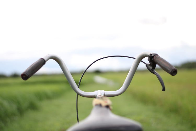 Handlebar of bicycle with blurred background.
