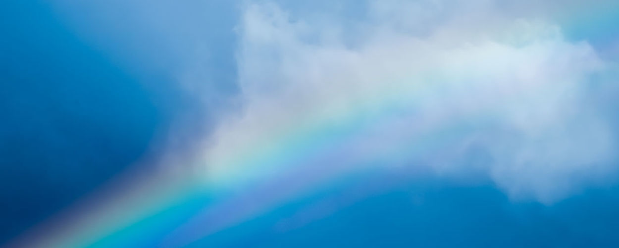 Low angle view of rainbow against blue sky