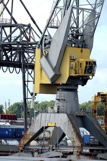 Crane at commercial dock against sky