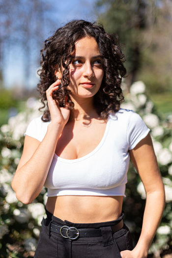 Young woman standing against trees