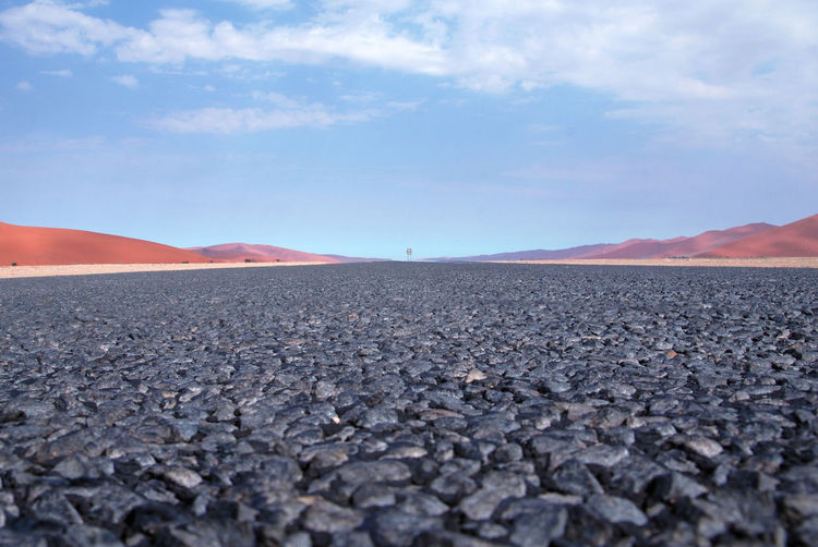 Surface level of barren landscape against sky