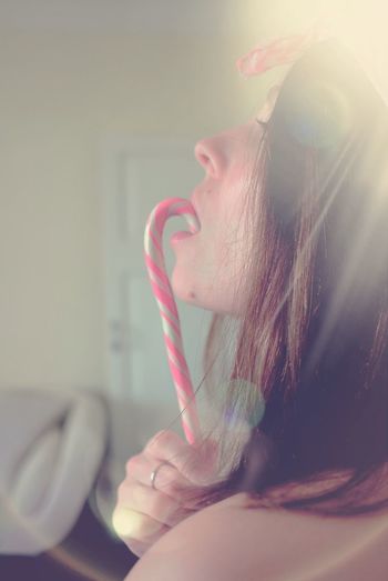 Close-up of young woman eating candy cane