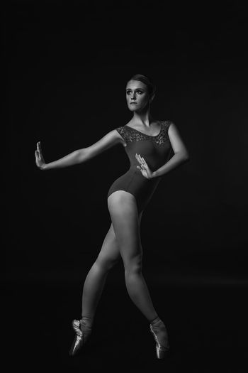 Ballet dancer dancing against black background