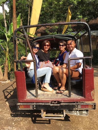 Portrait of happy friends sitting in off-road vehicle