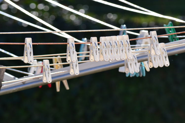 Close-up of clothespins hanging on railing