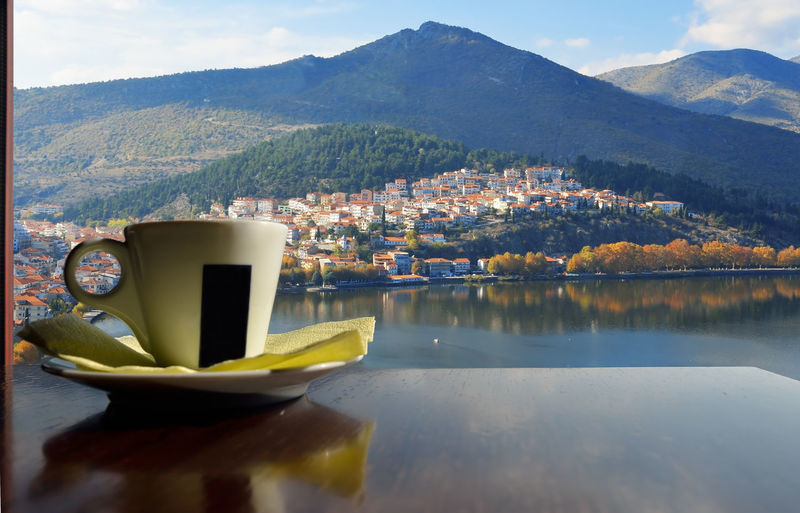Cup of coffee with window view of kastoria , greece