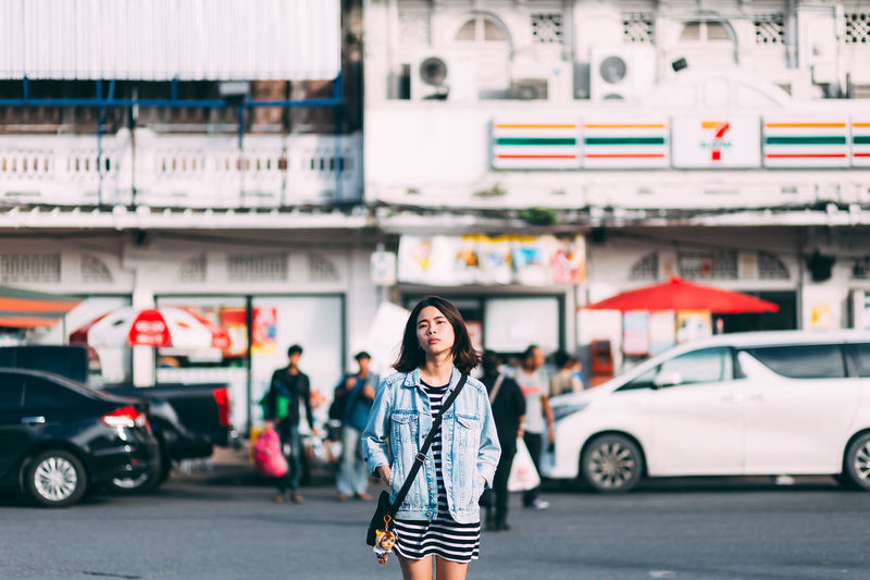 Portrait of woman standing on street in city