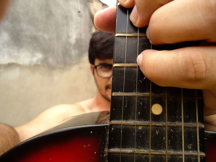 Close-up portrait of man playing guitar
