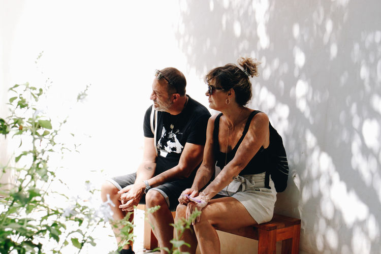 Side view of a couple sitting on field