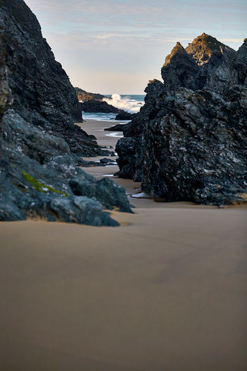 Surface level of rocks on beach against sky