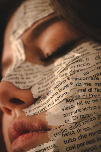 Close-up of teenage girl with paper on face