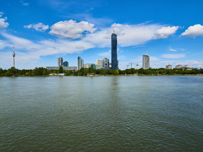 River by buildings against sky