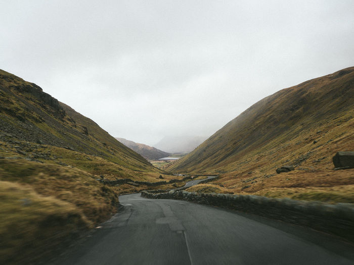 Road amidst mountains against sky