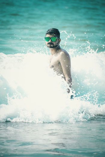 Man wearing sunglasses while standing in sea