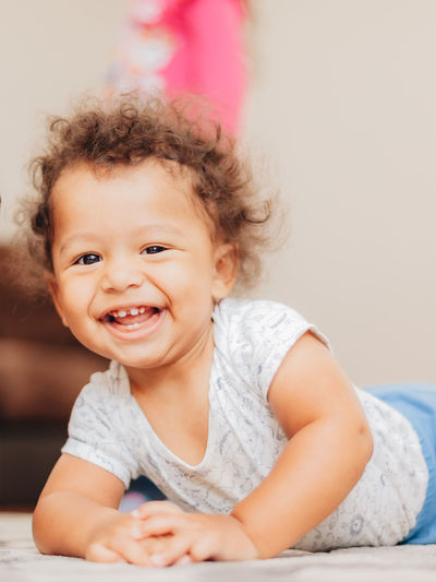 Portrait of cute mixed race or biracial baby boy with curly hair smiling 