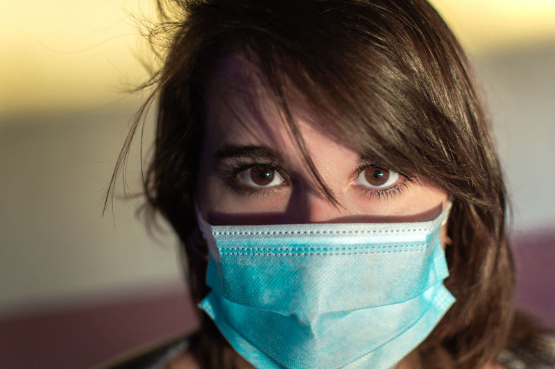 Close-up portrait of beautiful woman wearing flu mask outdoors