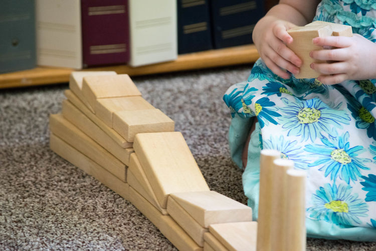 Midsection of girl stacking wooden toy blocks