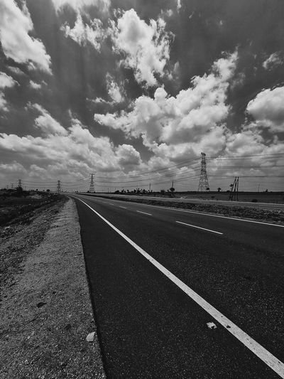 Empty road on field against sky