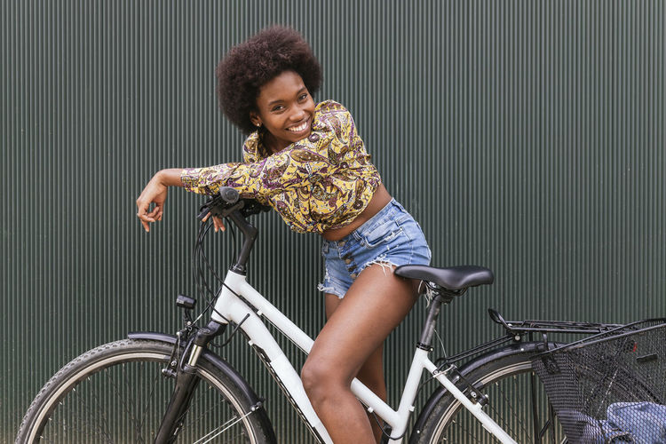 HAPPY WOMAN RIDING BICYCLE ON RAILING