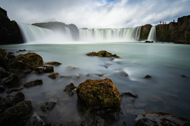 Scenic view of waterfall against sky