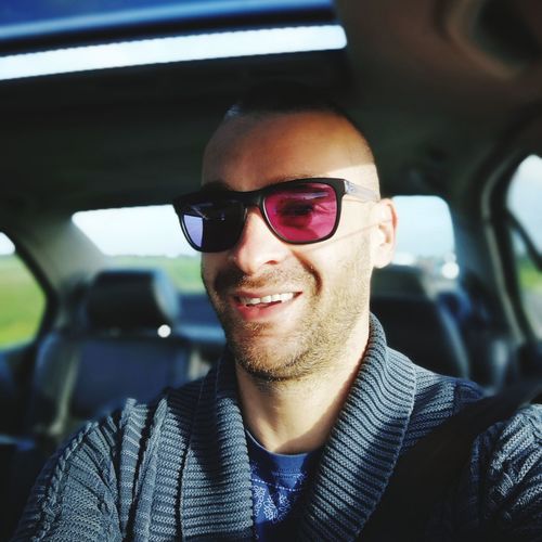 Portrait of mid adult man wearing sunglasses while sitting in car