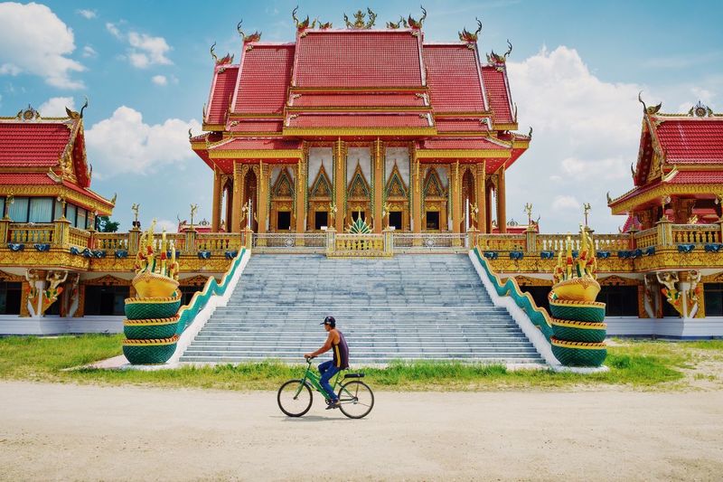 Man riding bicycle against temple
