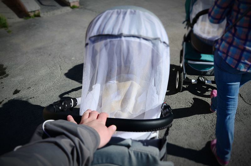 Cropped image of woman walking with baby stroller