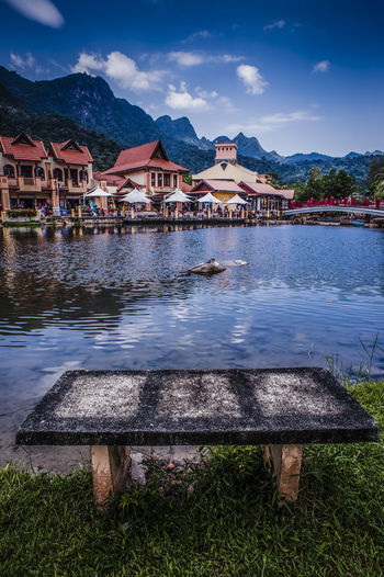 Lake by houses against blue sky
