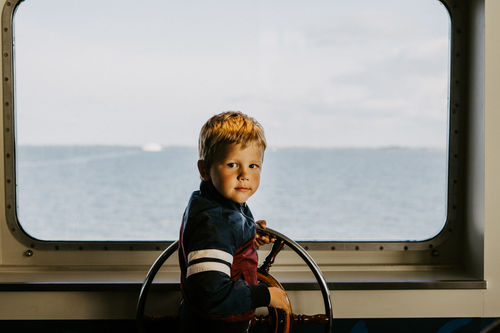 Portrait of boy in sea against sky