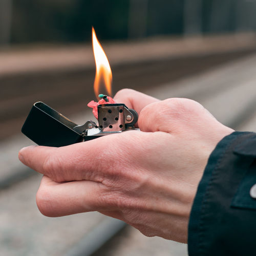 Close-up of hand holding lighter and bomb