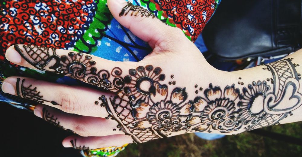 Cropped hand of woman with henna tattoo