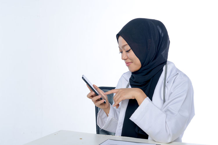 Low angle view of person using phone against white background