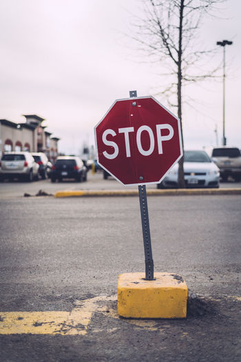 Stop sign on road with cars in background