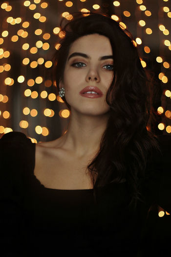 Portrait of beautiful young woman lights background christmas
