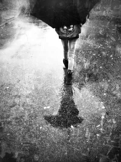 Low section of woman standing in puddle