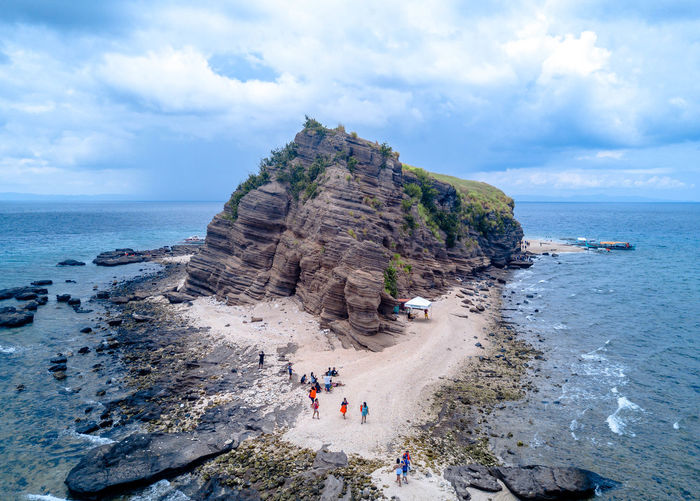 Rock formations on beach against sky