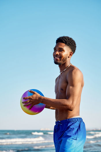 Portrait of shirtless man holding soccer ball