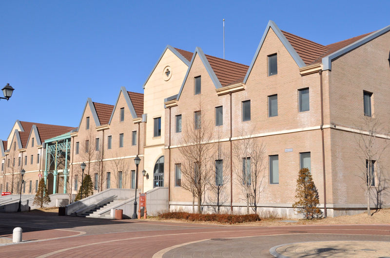 Street by buildings against clear blue sky