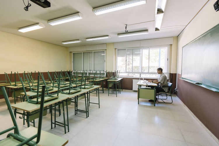 Math teacher sitting in empty classroom