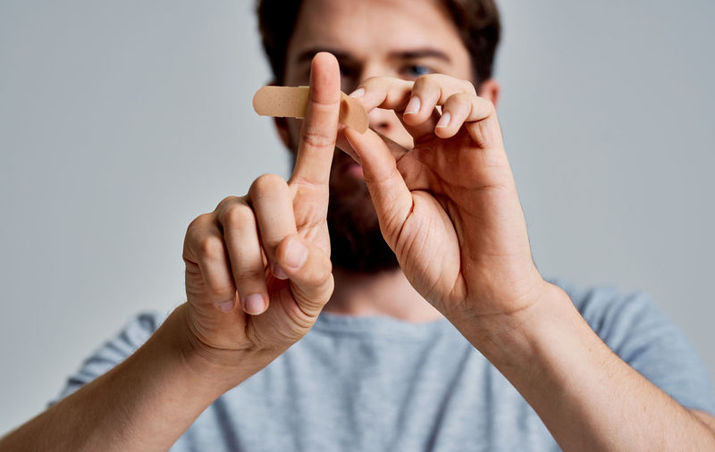 Man putting bandage on finger