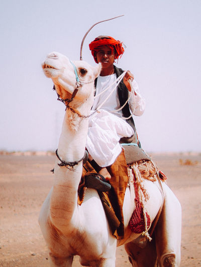 Bedouin young man with his camel in the desert 