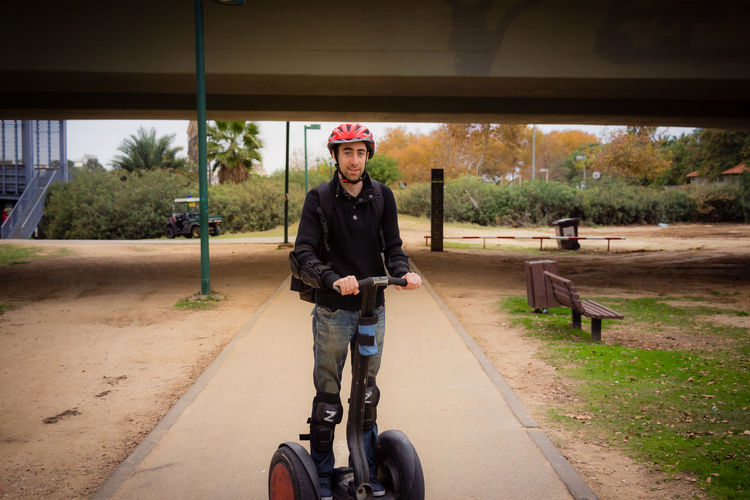 Portrait of young man standing on segway