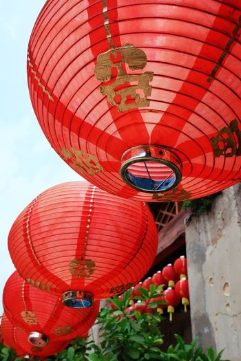 Low angle view of red lantern hanging against wall
