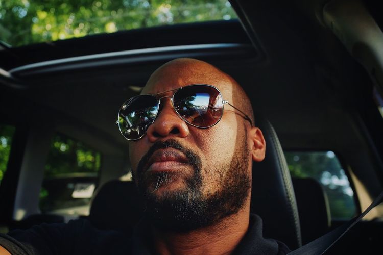 Portrait of man wearing sunglasses in car