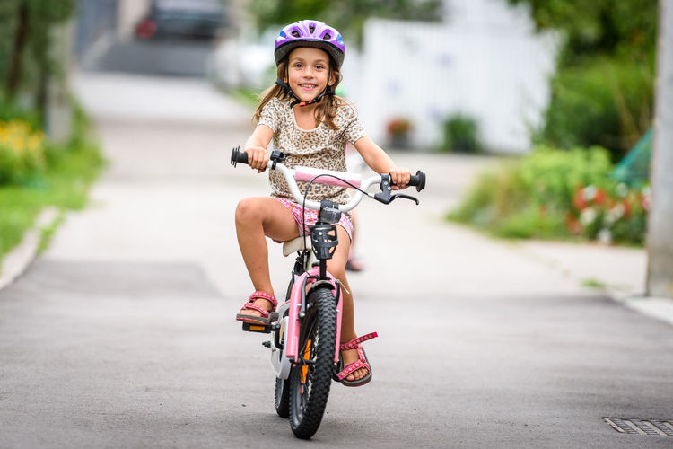 Girl riding bicycle on road