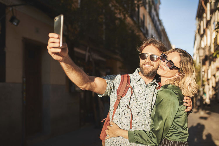 Couple doing selfie while walking outdoors